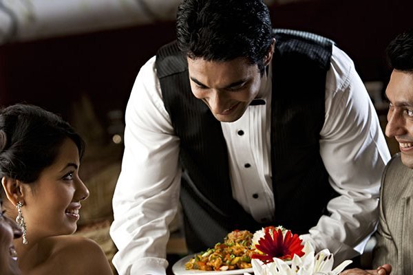 Server presenting a dish to guests